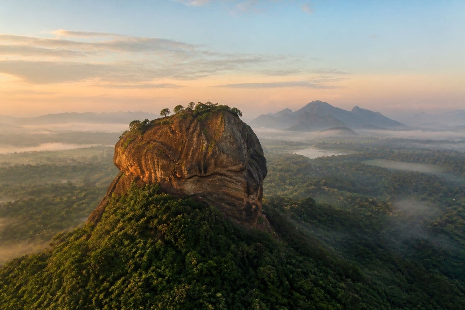 Sigiriya Rock Fortress rising above jungle mist
