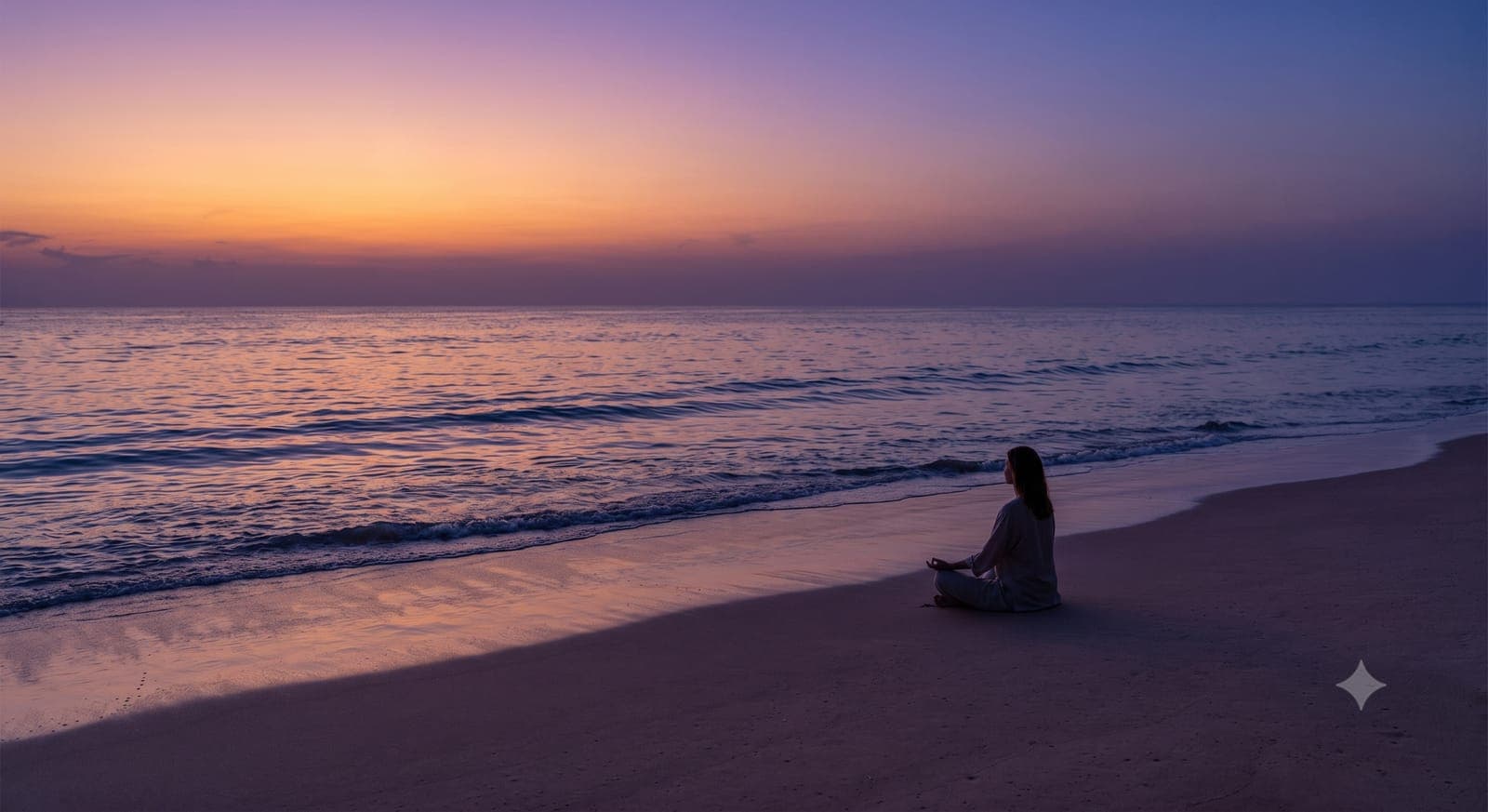 Silhouette of a person meditating on a quiet beach as the sun sets over the ocean