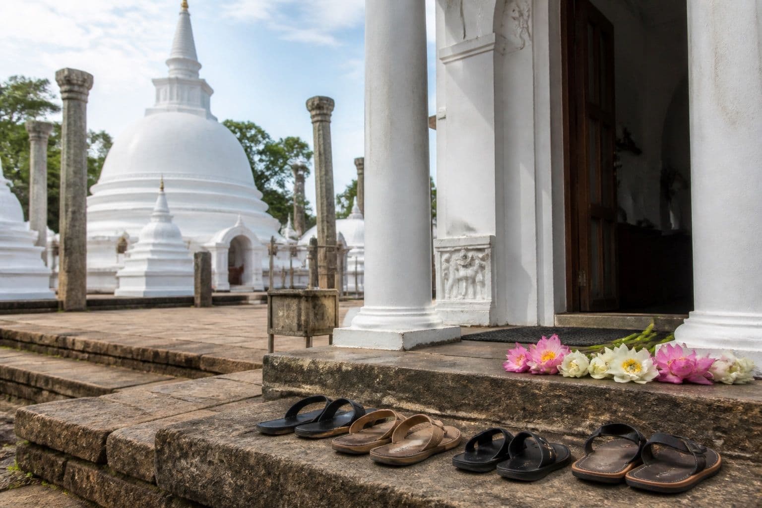 Buddhist temple entrance with dagoba and offerings in Sri Lanka